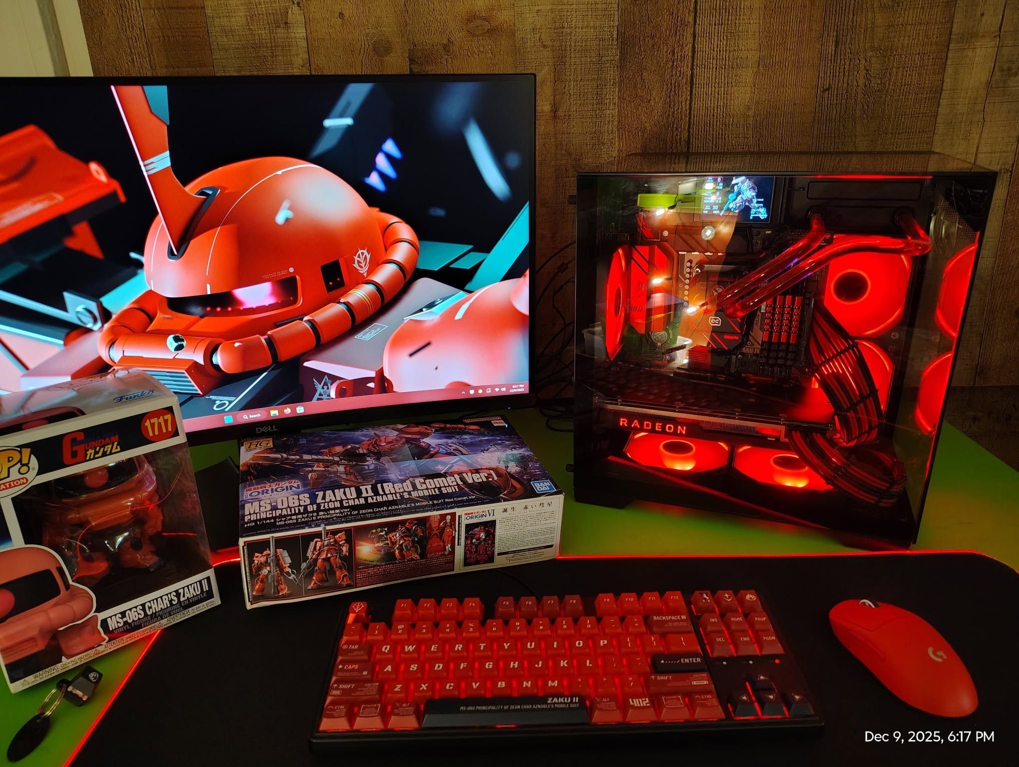 Red-lit custom desktop computer beside a matching keyboard and Gundam display